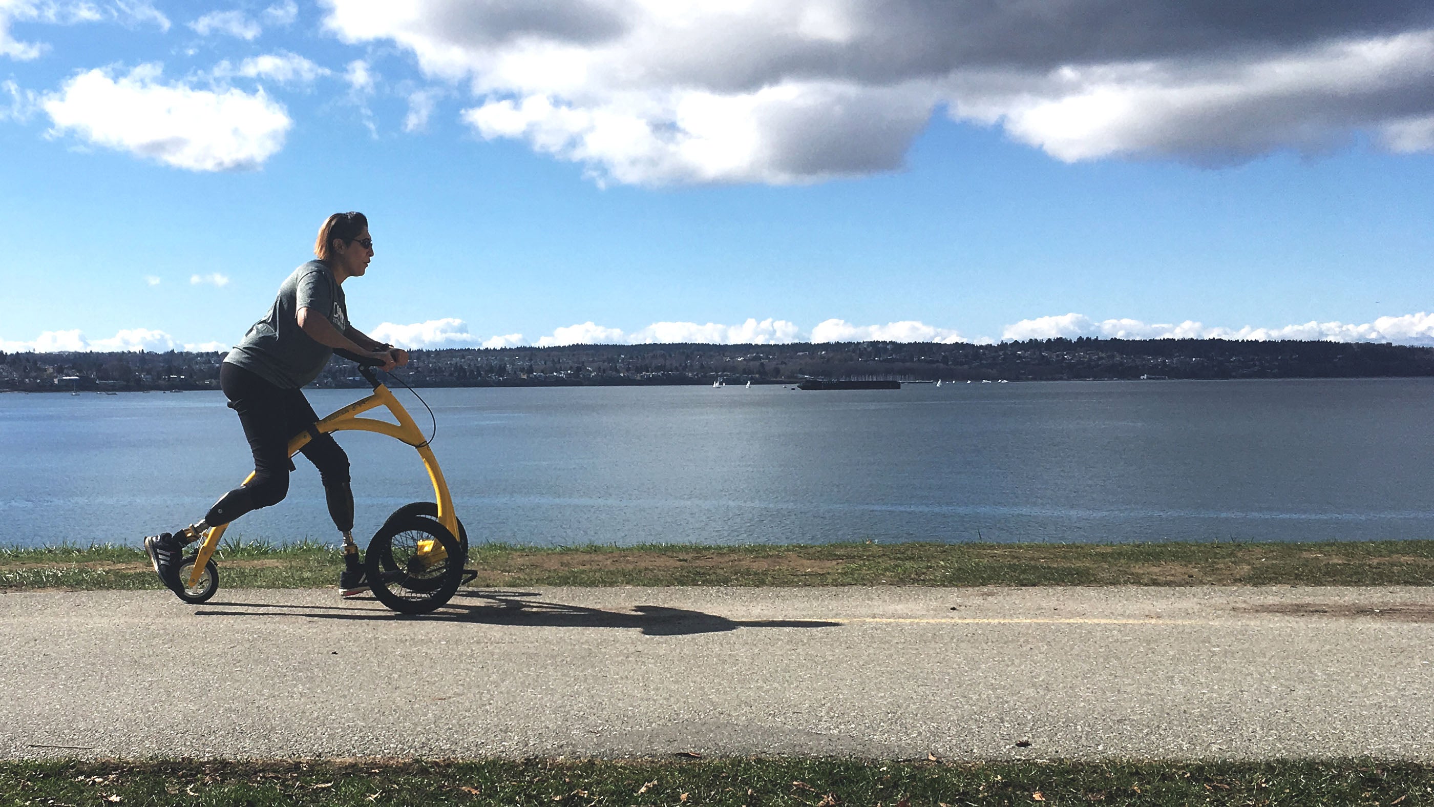 woman riding Alinker along a lake