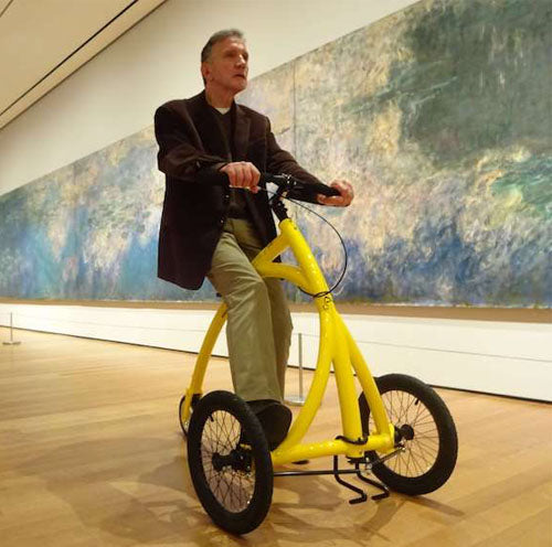 Man on an Alinker at a museum, interacting at eye level